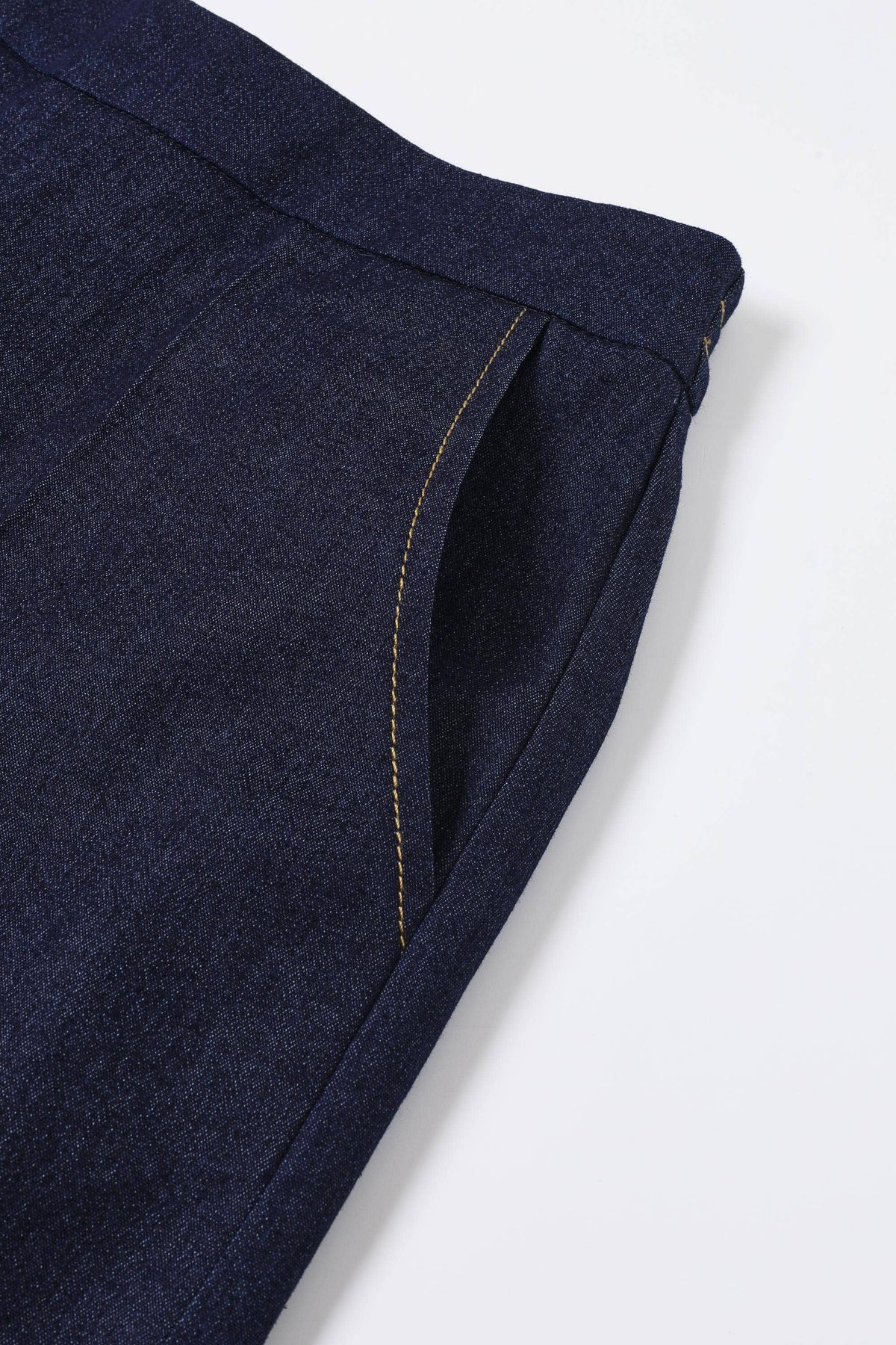 Close-up of dark blue denim fabric on a white background