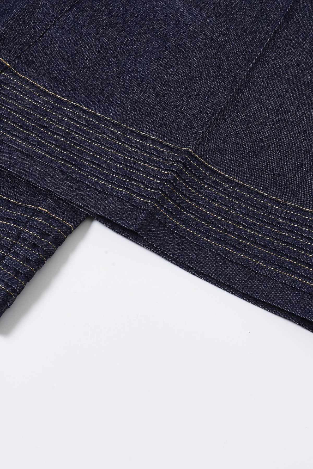 Close-up of dark blue denim fabric on a white background